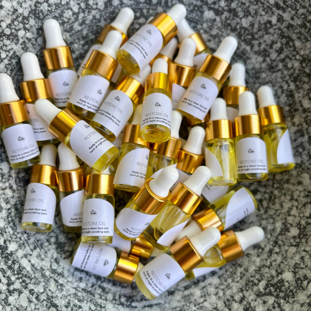 Collection of small bottles with dropper caps on a textured surface